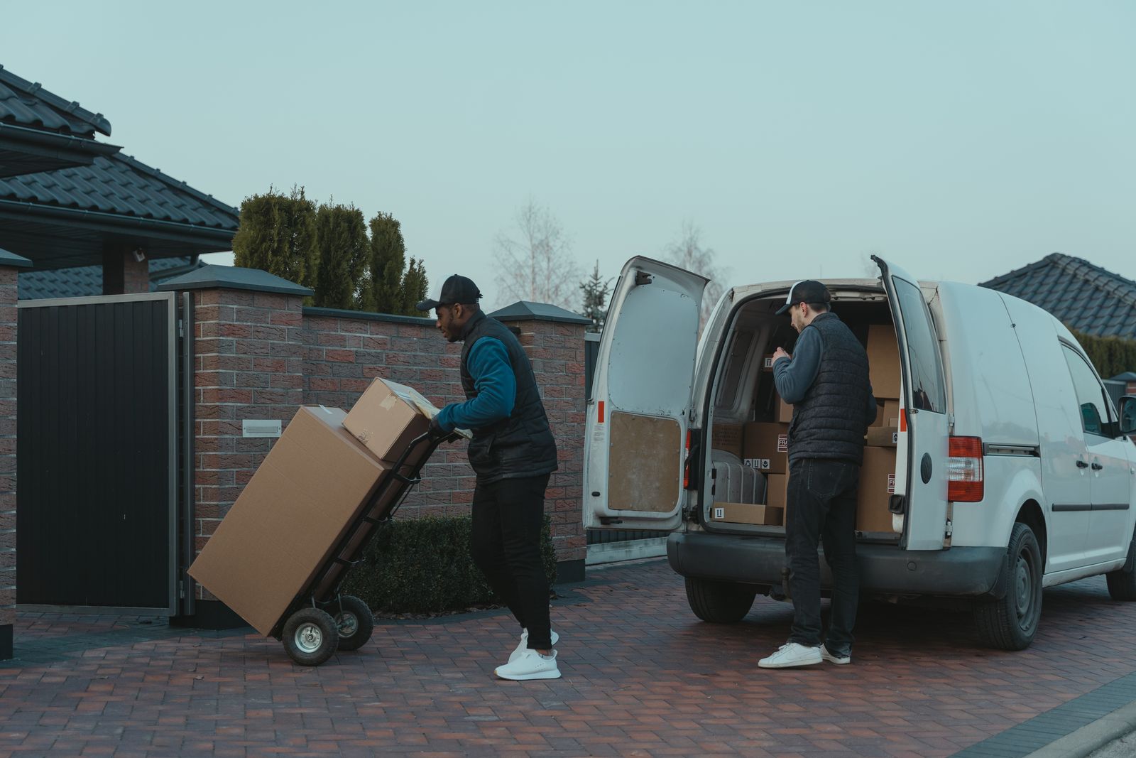Two delivery professionals unloading parcels from a van